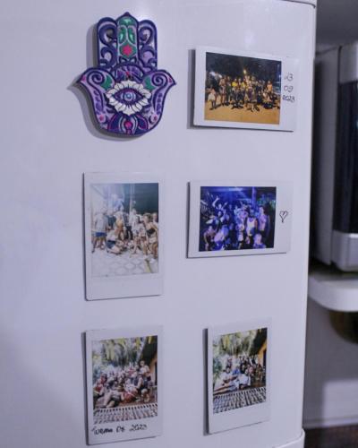 a wall with pictures and a clock on it at Hostel Trópico de Capricórnio - Tenório in Ubatuba