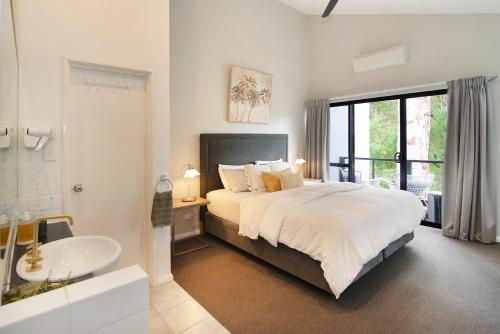 a bedroom with a large bed and a sink at MARGARET FOREST RETREAT Apartment 129 - Located within Margaret Forest, in the heart of the town centre of Margaret River, spa apartment! in Margaret River Town