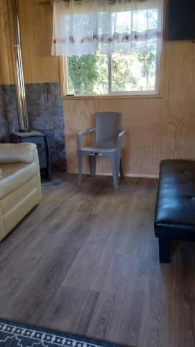 un soggiorno con un divano e una sedia di Cabañas Kapüra a Hornopiren