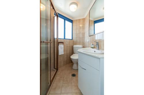a bathroom with a toilet and a sink and a shower at Heritage 301 in Tuncurry
