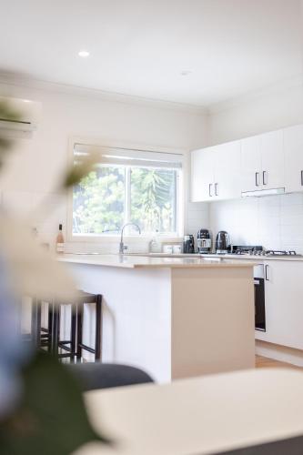 a white kitchen with a sink and a window at Bella Boutique in Healesville