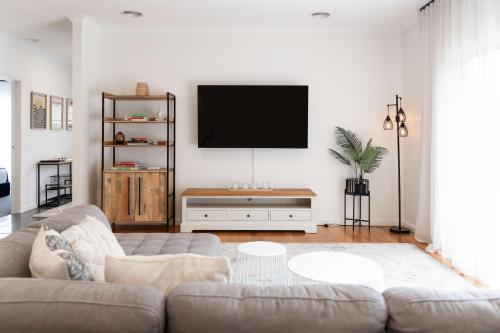 a living room with a couch and a flat screen tv at Bella Boutique in Healesville