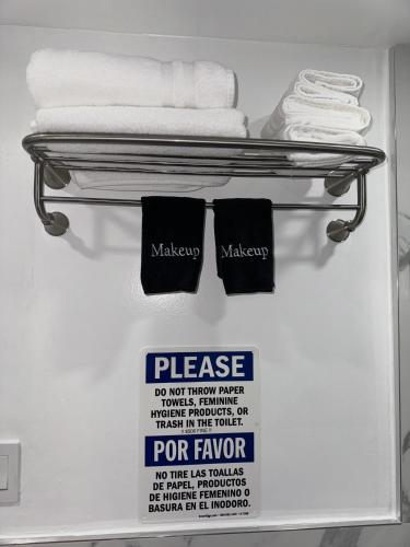 a towel rack with towels and a sign in a bathroom at Luna y Sol Calle 8 in Miami