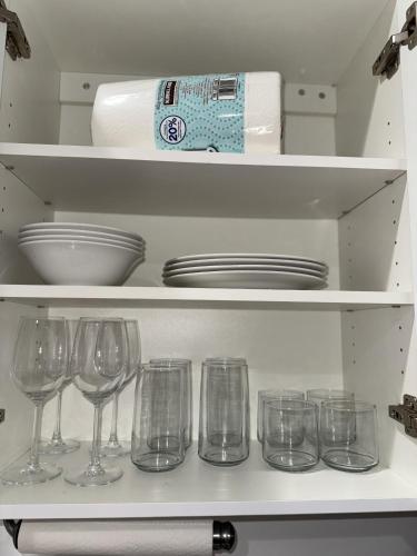 a shelf with wine glasses and plates in a refrigerator at Luna y Sol Calle 8 in Miami