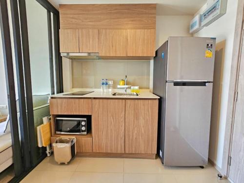 a small kitchen with a refrigerator and a sink at La Casita Condo Hua Hin 6 in Hua Hin