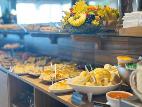 a buffet line with many different types of food at Netuanah Praia Hotel in João Pessoa