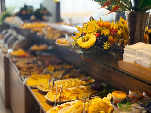 a buffet line with many different types of food at Netuanah Praia Hotel in João Pessoa