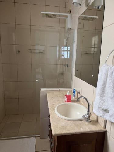 a bathroom with a sink and a shower at Acomodação no centro da cidade com piscina in São Gabriel