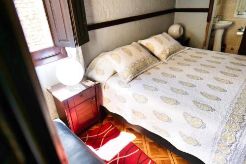 a bedroom with a bed and a table with a lamp at Hostal Boonen in Santiago