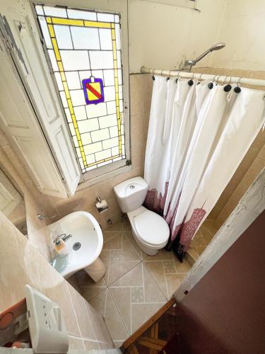 a bathroom with a toilet and a sink and a window at Hostal Boonen in Santiago