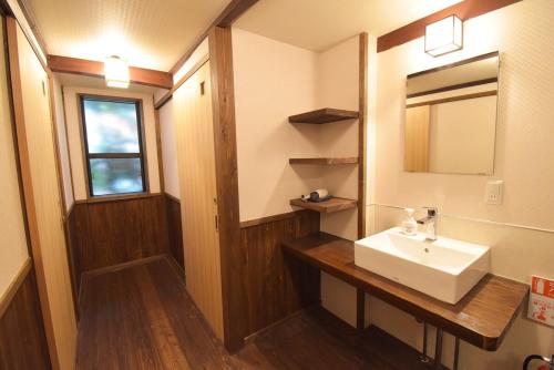 un baño con lavabo y espejo en 油屋別邸, en Beppu