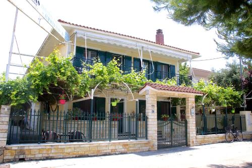 una casa con una valla de hierro forjado delante de ella en Asterias, en Koronisía