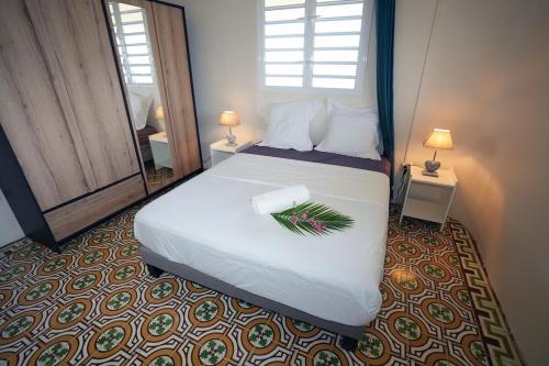 een slaapkamer met een wit bed met een gedeelte erop bij Villa Amandine in Fort-de-France