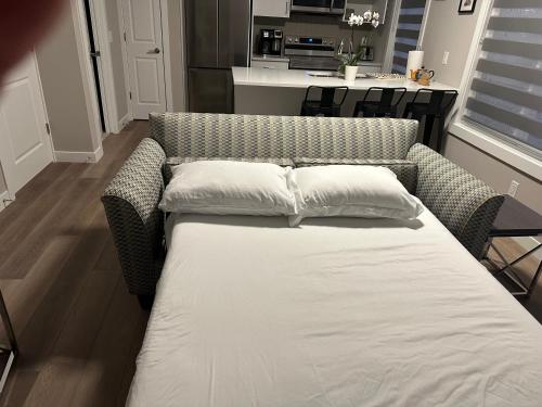 a bed with two pillows on it in a room at Cozzy & Brand New Apartment, Near Banff Hwy in Calgary