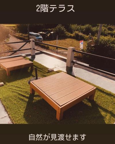 two benches sitting in the grass in a park at farm stay Jammin in Itoshima