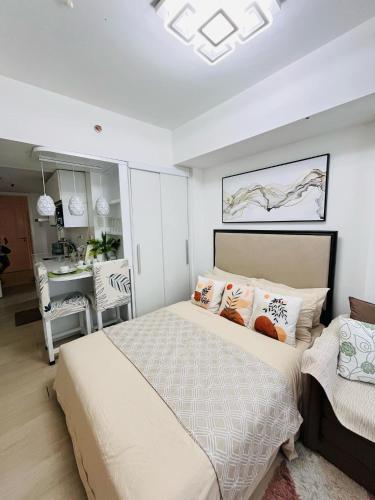 a bedroom with a large bed and a table at Azure North- Serenity Homes by J&J Condo rentals in Lagundi