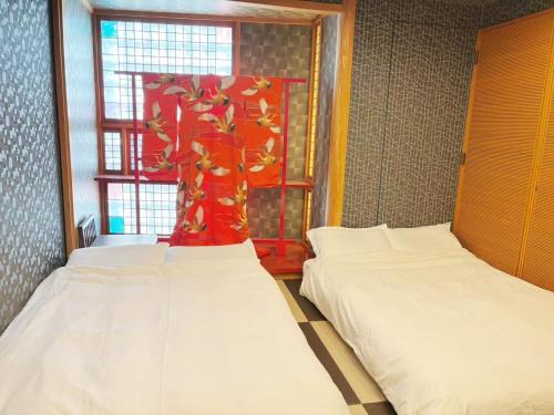 two beds in a room with a window at 颯House 4 in Osaka