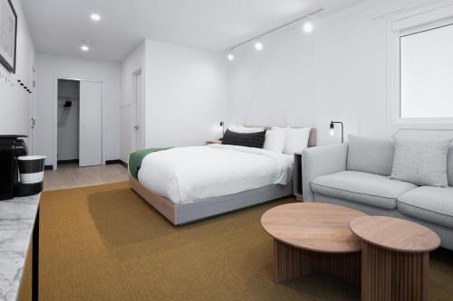a bedroom with a bed and a couch and a table at VRGE Revelstoke in Revelstoke