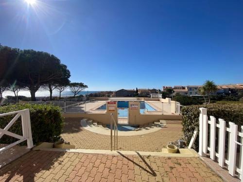 un bâtiment avec une piscine et une clôture dans l'établissement Appartement T2 Cabine - Parking - Piscine - 6 Personnes - FR-1-795-4, à Fleury