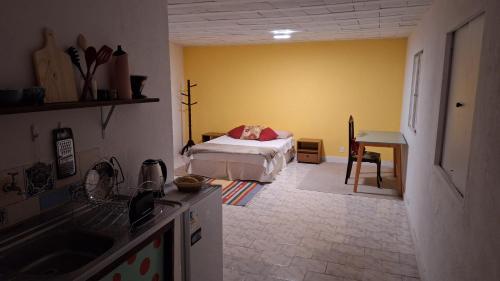 a kitchen with a bed in a yellow room at Casinha Laranja in Rio de Janeiro