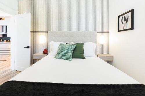 a bedroom with a large white bed with green pillows at Lux Newly Remodeled DT, Patio, Fully Stocked 5Bd, 3Ba in Denver