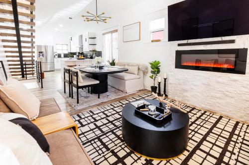 a living room with a table and a fireplace at Lux Newly Remodeled DT, Patio, Fully Stocked 5Bd, 3Ba in Denver