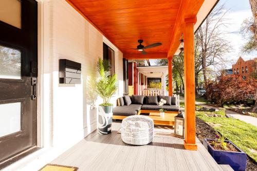 a covered porch with a couch and a table at Lux Newly Remodeled DT, Patio, Fully Stocked 5Bd, 3Ba in Denver