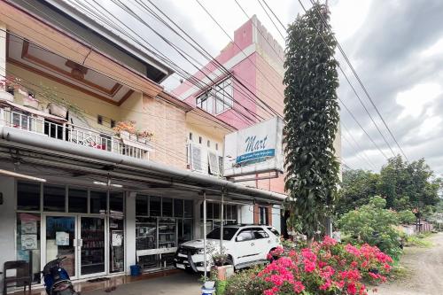 a white car parked in front of a building at RedDoorz Syariah at Homestay Haji Soma Makale in Pongtiku Airport