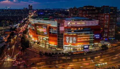 a large building with lights on in a city at night at Chaoyang Joy City Hardcover Apartment in Beijing