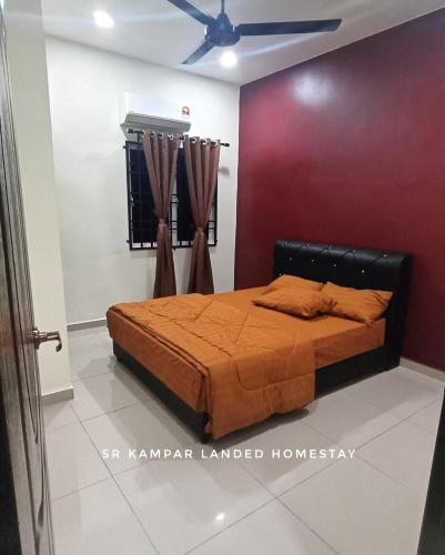 a bedroom with a bed and a red wall at SR Kampar 2-Storey LANDED HOMESTAY in Kampar
