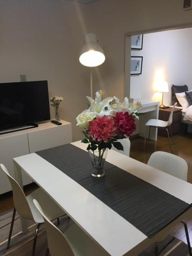 a dining room table with a vase of flowers on it at Apartment in Narita 225 in Narita