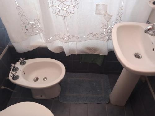 a bathroom with a sink and a toilet and a shower curtain at Casa Bela in Villa Carlos Paz