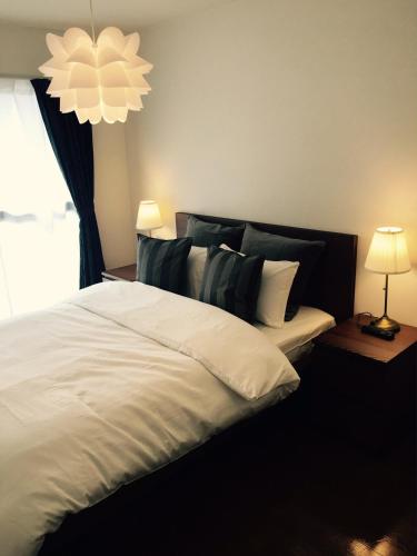 a bedroom with a large white bed with a chandelier at Apartment in Narita 225 in Narita