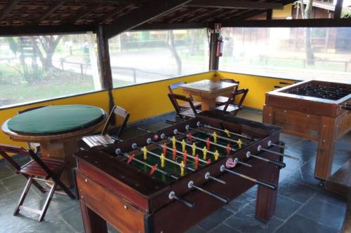 une chambre avec un baby-foot et des chaises dans l'établissement Barretos Country Resort - Apto 1 Quarto até 5 Pessoas, à Barretos