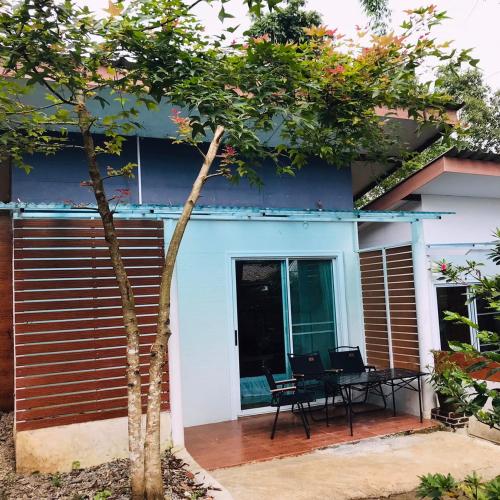 a blue house with a table and chairs in front of it at Palacoffeehouse ปางอุ๋ง in Ban Huai Makhuea Som