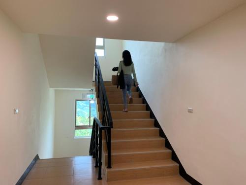 a woman walking down a staircase in a house at Green Field Mountain Villa in Hualing