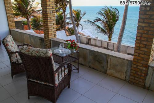 a table and chairs on a balcony overlooking the ocean at Casa Vista ao Mar - Paisagem Deslumbrante e Localização Perfeita in Canoa Quebrada