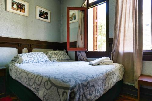 a bedroom with a bed with a mirror and a window at Hostal Boonen in Santiago