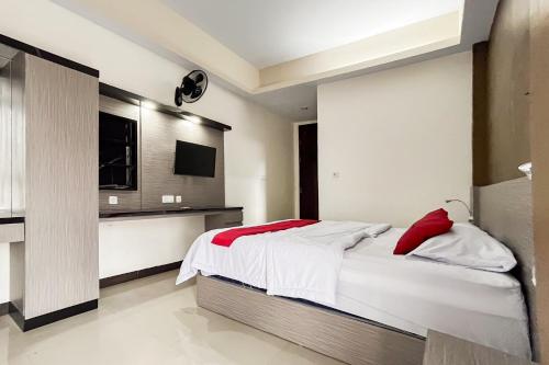 a bedroom with a bed and a flat screen tv at RedDoorz Syariah at Homestay Haji Soma Makale in Pongtiku Airport