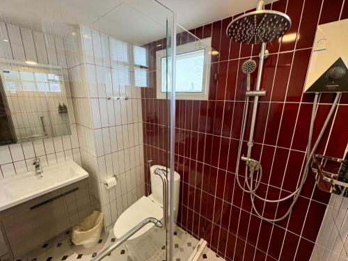 a bathroom with a shower and a toilet and a sink at U Sabai Hotel Bangkok in Bangkok