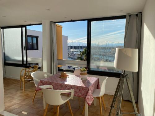 une salle à manger avec une table et des chaises et une grande fenêtre dans l'établissement Port Leucate: T2 Climatisé, WIFI, Animaux ok, Parking Sécurisé - FR-1-798-52, à Leucate