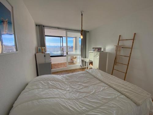une chambre avec un lit et une grande fenêtre dans l'établissement Port Leucate: T2 Climatisé, WIFI, Animaux ok, Parking Sécurisé - FR-1-798-52, à Leucate
