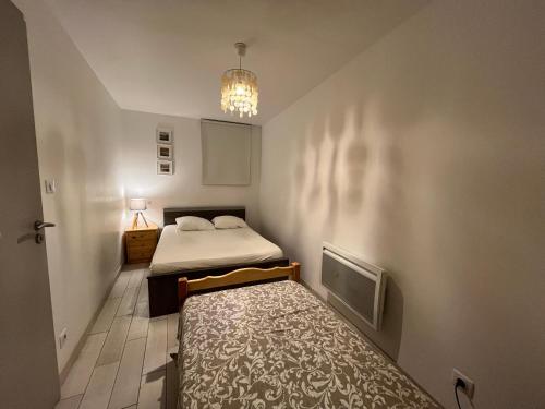 une petite chambre avec deux lits et une télévision dans l'établissement Appartement cosy Sète, 2 pièces, 4 pers, rez-de-chaussée, WIFI, animaux admis - FR-1-338-599, à Sète