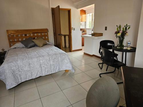 a bedroom with a bed and a table and chairs at Habitación #1 Mascota in Guadalajara