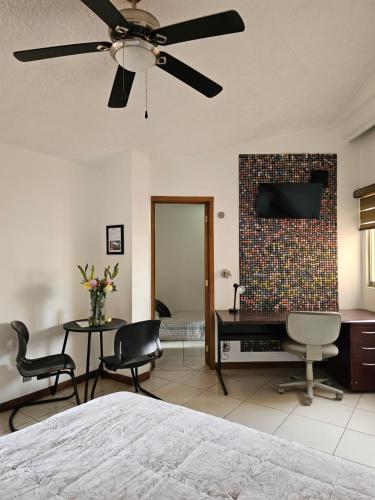 a bedroom with a bed and two chairs and a desk at Habitación #1 Mascota in Guadalajara
