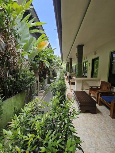 a patio with benches and plants in a building at Classic House By Green View in Ubud