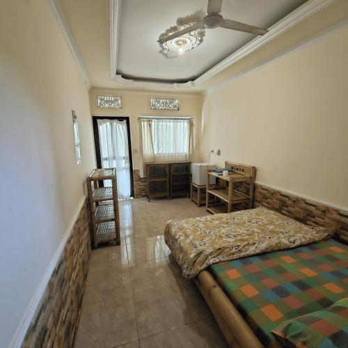 a bedroom with a bed and a desk in it at Classic House By Green View in Ubud