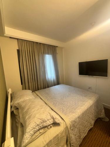 Un dormitorio con una cama y un televisor de pantalla plana. en Hotel Estaza Executive Moema Ibirapuera com garagem piscina 202, en São Paulo