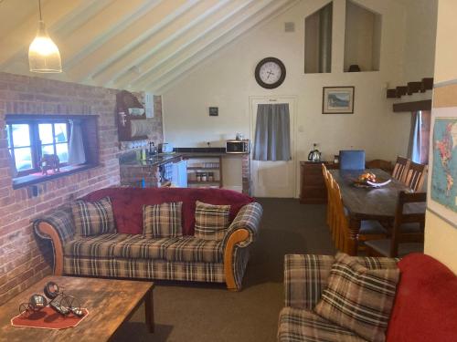 a living room with a couch and a table at Arden Country House BnB - Entire house to yourself -peace in the country in Dunedin