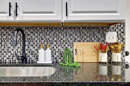 a kitchen with white cabinets and a sink and a counter top at 4BR Near Lucas Oil º IUPUI º Convention Centerº DT in Indianapolis